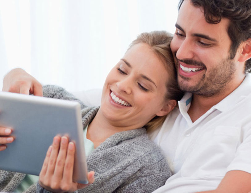 Happy couple looking at tablet